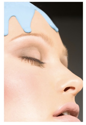 creatieve foto van een beauty model door professionele fotograaf met blauwe verf op haar hoofd en naturel make up